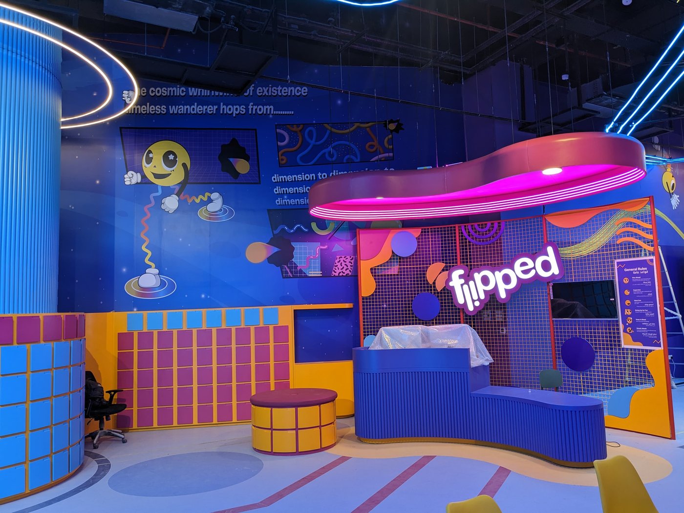 The Flipped reception desk with the illuminated logo sign above it